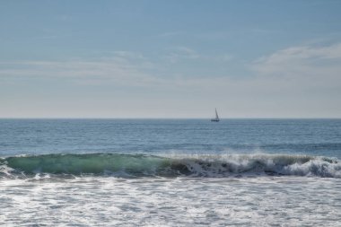 Sörfçülerle ve teknelerle dolu Carcavelos plajı.