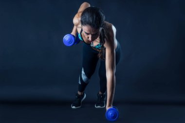 Kadın, karanlık arka planda izole edilmiş spor yapıyor..