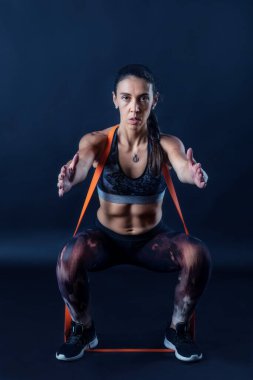 Kadın, karanlık arka planda izole edilmiş spor yapıyor..