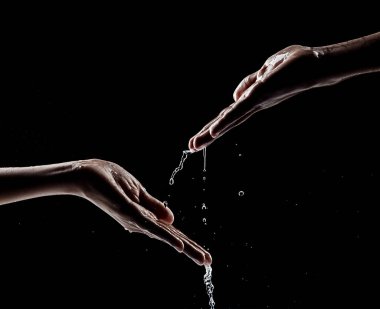 Afrikalı erkek eli su ve siyah arkaplan ile etkileşimde.