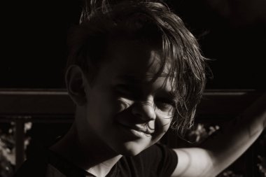 Balkonda gün batımının tadını çıkaran küçük bir çocuğun portresi.