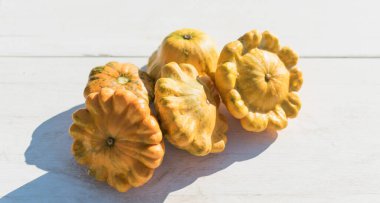 Bahçedeki masada biraz kabak var. Sebzeler akşam güneşinde sarıdır.