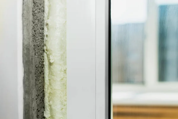 Yeni beyaz plastik pencere. Açılışın köpükle izolasyonu