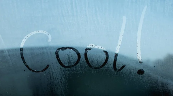 The inscription on the fogged glass on a cool morning, the word cool