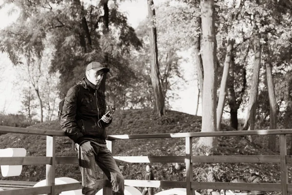 Młody Facet Plecakiem Podczas Podróży Parku Słuchający Muzyki Czarno Biały — Zdjęcie stockowe