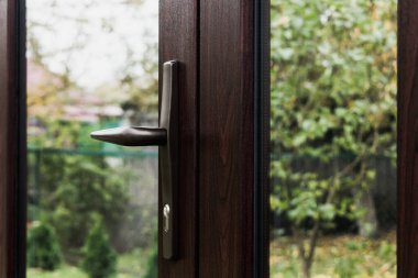 Giriş kapısının kapı kolu koyu plastikten, aynalı çift camlı pencerelerden yapılmış.