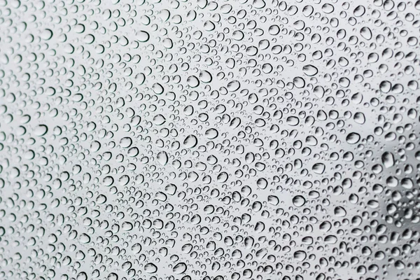 Small raindrops on the car window in cloudy weather