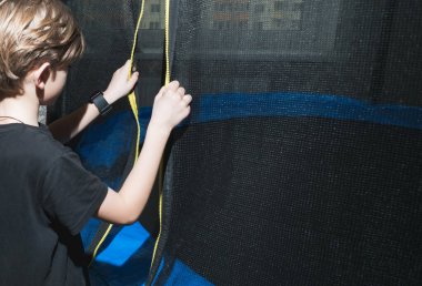 Küçük bir çocuk dairesindeki güvenlik ağıyla trambolinde zıplayacak.