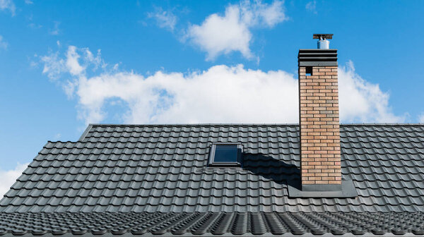 A fragment of the roof of a metal profile of a new house under construction, with a pipe and windows