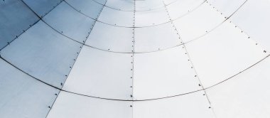 Büyük metal levhalarla kaplanmış bir yapının parçası.