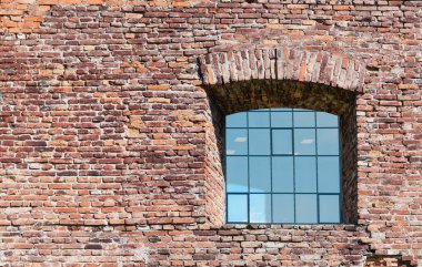 Yeni bir penceresi olan kırmızı tuğlalı bir kalenin parçası.