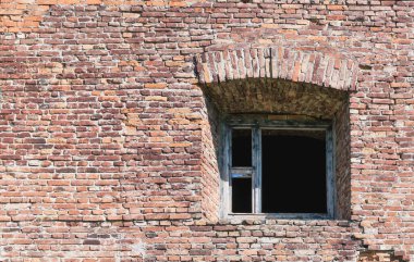 Eski bir penceresi olan kırmızı tuğlalı bir kalenin parçası.