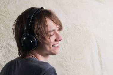 Kulaklıklı, müzik dinleyen genç bir adamın portresi.