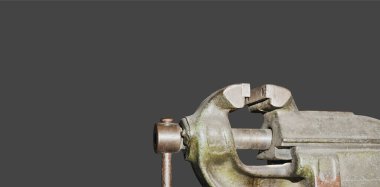 Atölyedeki büyük çilingir mengenesi koyu bir arka planda.