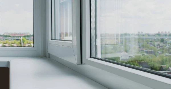 White plastic window with welding on the balcony, and plastic window sill