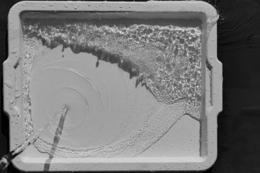 Işık tepsisindeki berrak, şeffaf suyun köpürmesi ve sıçraması.