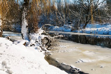 Kışın güneşli bir günde buz ve karla kaplı bir nehir.