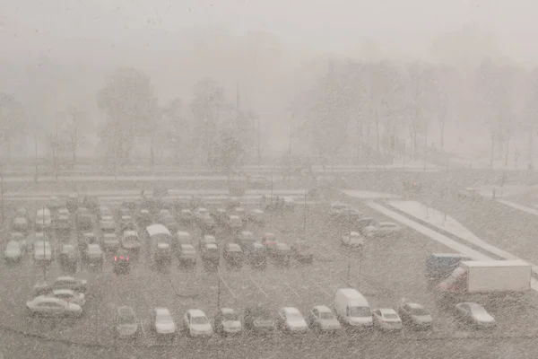 一个模糊的图像 在冬季暴风雪中 停车场上有汽车 — 图库照片