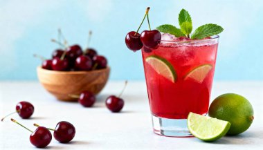 Göz hizasında yakın çekim, temiz bir bardakta taze kiraz ve nane yapraklarıyla süslenmiş parlak kırmızı bir kokteyl yakalar..