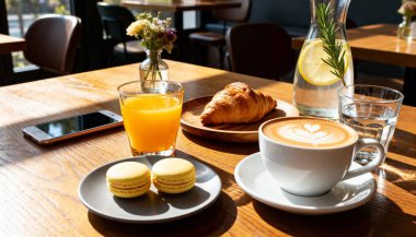 Kırsal bir tahtanın üzerinde taze pişmiş kruvasan ile servis edilen kalp şeklinde köpüklü nefis bir latte. Konforlu kafe anları ve gurme kahvaltı deneyimleri sergilemek için mükemmel..