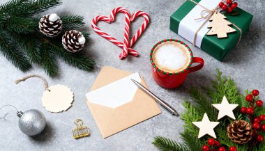 Noel kompozisyonu düzdü. Kare kağıt boş, çam ağacı dalları, renkli arka planda noel süslemeleri. Üst görünüm, metin için boşluk kopyala.