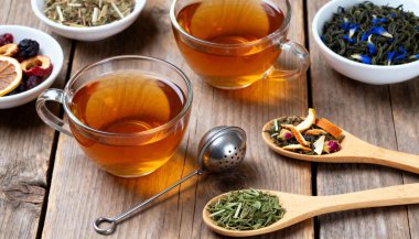 Farklı bitkisel çaylar ve ahşap masadaki kuru yapraklar.