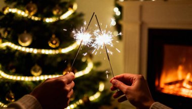 Noel ağacının arka planında bir maytap yanıyor.