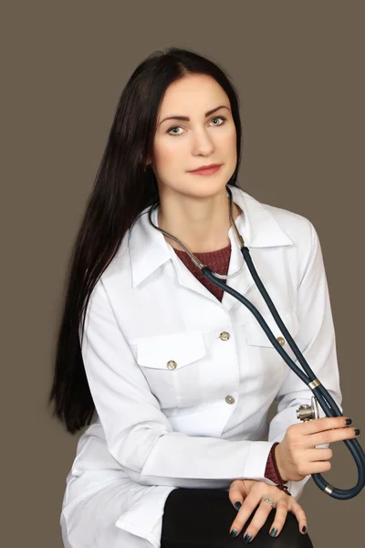A mulher jovem o doutor em um uniforme branco médico com um ste — Fotografia de Stock