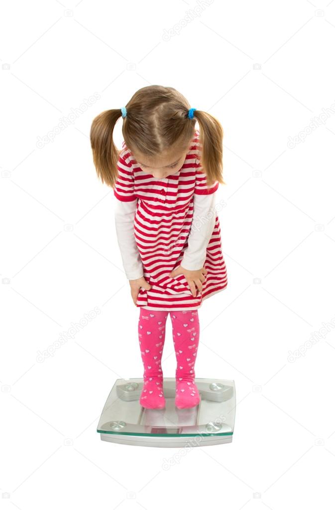 Little funny girl stand on scales