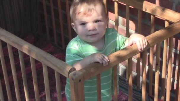 Das kleine Kind lacht in der Krippe — Stockvideo