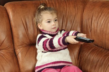 küçük kız elinde uzaktan kumanda ile