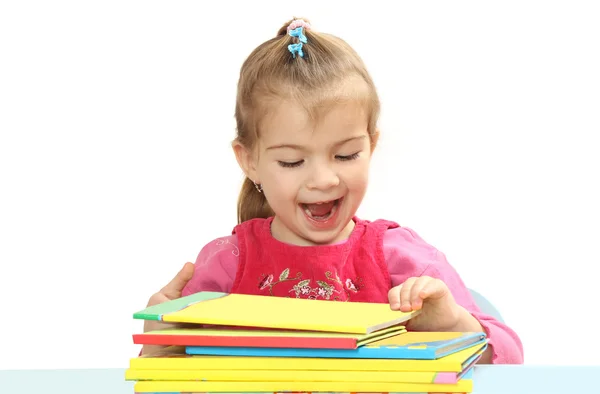 La bambina con libri a un tavolo — Foto Stock