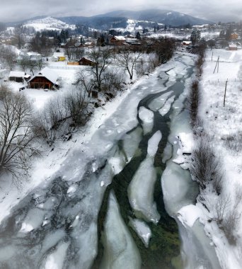 Soğuk bir günde nehirde donmuş taşların kasvetli manzarası. Mekan: Karpat Dağları, Ukrayna, Avrupa.