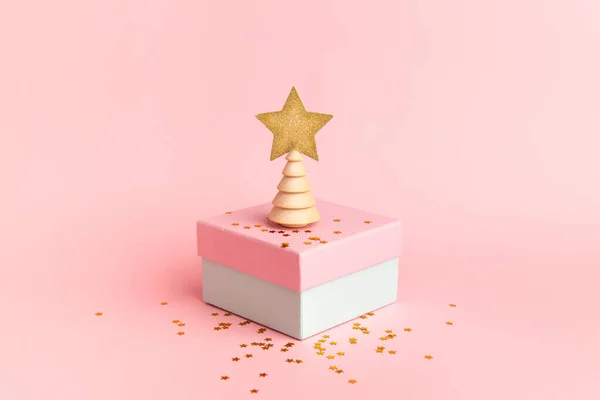 Scatola regalo rosa con albero di Natale con stella e scintille su sfondo rosa — Foto Stock