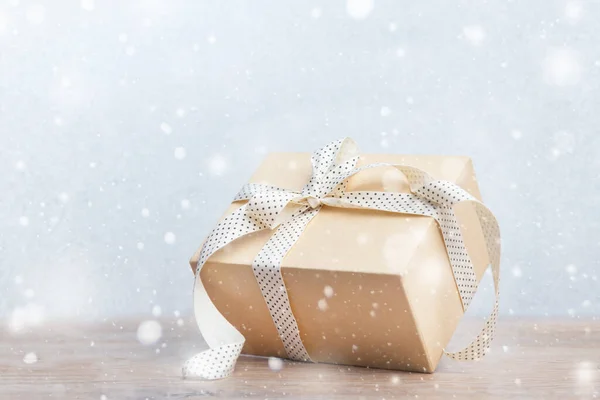 Kerstcadeaus doos met lint op glitter blauwe en houten ondergrond met sneeuw. Nieuwjaarskaart 2020. — Stockfoto