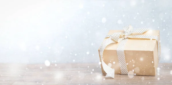 Kerstcadeaus doos met lint op glitter blauwe en houten ondergrond met sneeuw. Nieuwjaarskaart 2020. — Stockfoto
