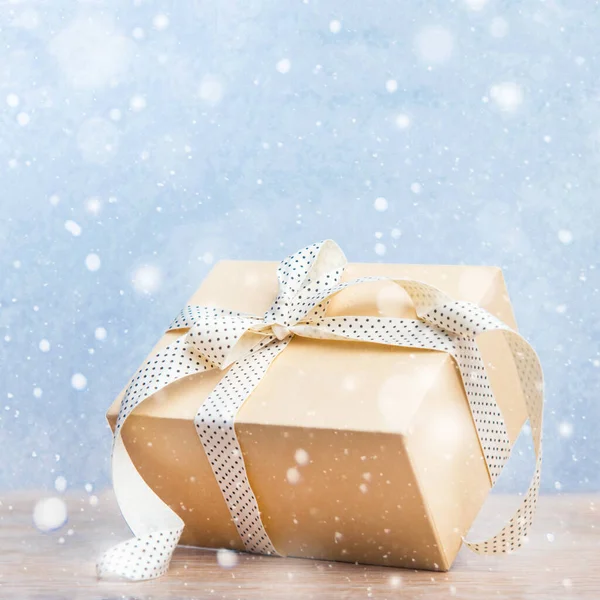 Kerstcadeaus doos met lint op glitter blauwe en houten ondergrond met sneeuw. Nieuwjaarskaart 2021. — Stockfoto