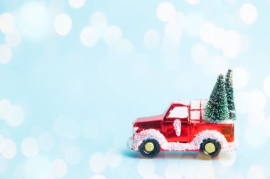Noel ağacı olan kırmızı araba ve mavi arka planda hediyeler.. 