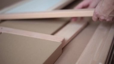 Adam katlanmış mobilyaları karton bir kutudan yakın plan çeker.
