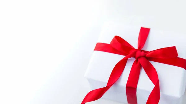 Witte kraft geschenkdoos met rood lint strik op witte achtergrond met plaats voor tekst. kopieer ruimte Valentijnsdag kaart — Stockfoto
