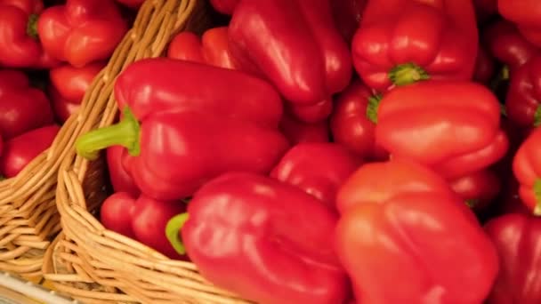 Sladký červený pepř v proutěném koši na pultu v supermarketu. Přesunout snímek — Stock video