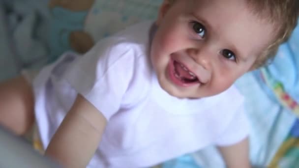 4k portré aranyos kisfiúról, aki mosolyog. baba az ágyban — Stock videók