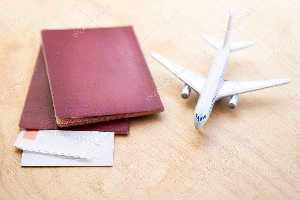 background with a model airplane and lying next to airline tickets and passports on a wooden table with copy space. travel concept.