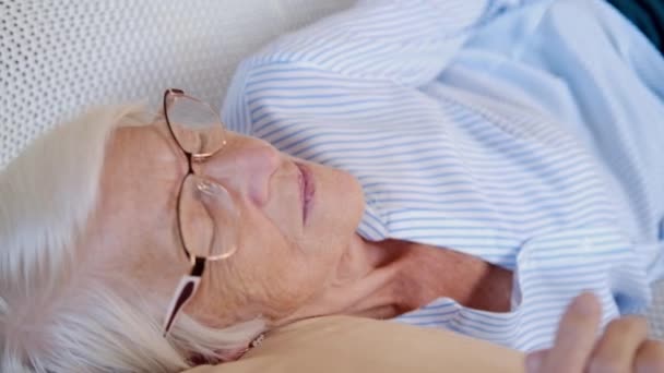 Närbild porträtt av kaukasisk glad lugn äldre kvinna sova eller koppla av på bekväm soffa hemma. tar en tupplur eller mediterar och vilar på soffan. stressfritt, fredskoncept — Stockvideo