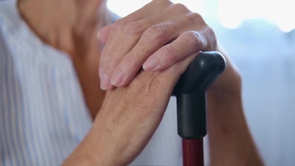 Caucasienne vieille grand-mère aînée tenant bâton de canne à pied dans les mains. vieilles mains ridées d'une grand-mère avec un gros plan de la canne. concept de solitude dans le vieil âgedouleur dans les articulations des mains. ostéoporose — Video