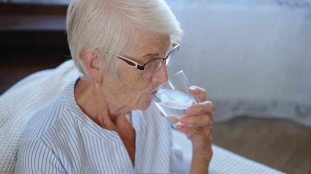 Porträtt kaukasisk frisk äldre vuxen kvinna som håller glas dricka färskt mineralrent vatten hemma. Bevarande av hälsan i begreppet ålderdom. — Stockvideo