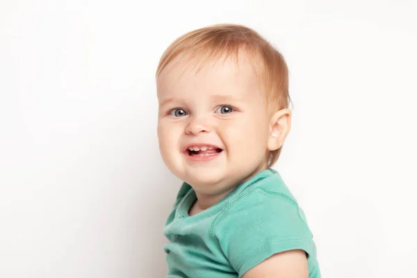Dítě chlapeček v zeleném tričku se šťastně směje při pohledu na kameru izolovanou na bílém pozadí. Koncept péče o děti a výchovy. — Stock fotografie