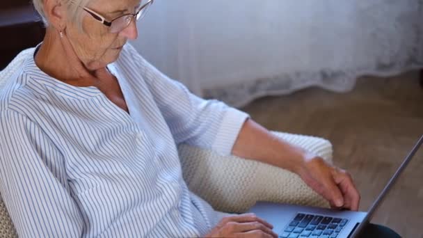 Šťastná žena středního věku na laptopu, která pracuje na počítači a dělá papírování. starší žena psaní na počítači a nakupuje online nakupování. — Stock video