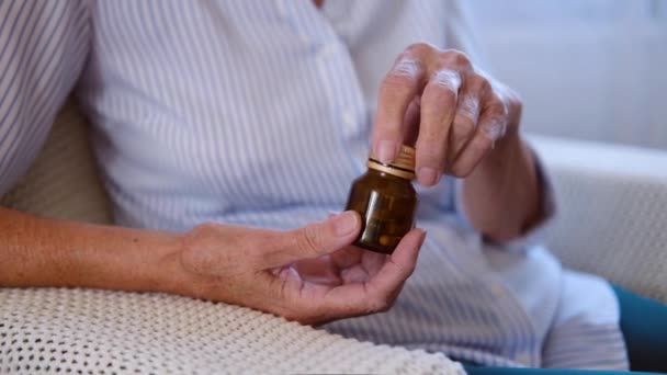 Close up view of Senior adult woman hand holding painkiller pills pouring two capsules from meds bottle. old elderly grandmother taking medicine. health care. pharmacy and treatment concept — Stock Video