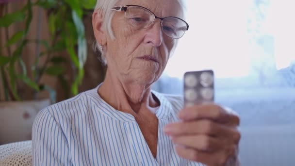 Yaşlı Kafkas kıdemli kadın ilaç etiketini okuyor. Yaşlılar sağlık hizmetleri, eczane konsepti, kapatın. Büyükanne portresi — Stok video